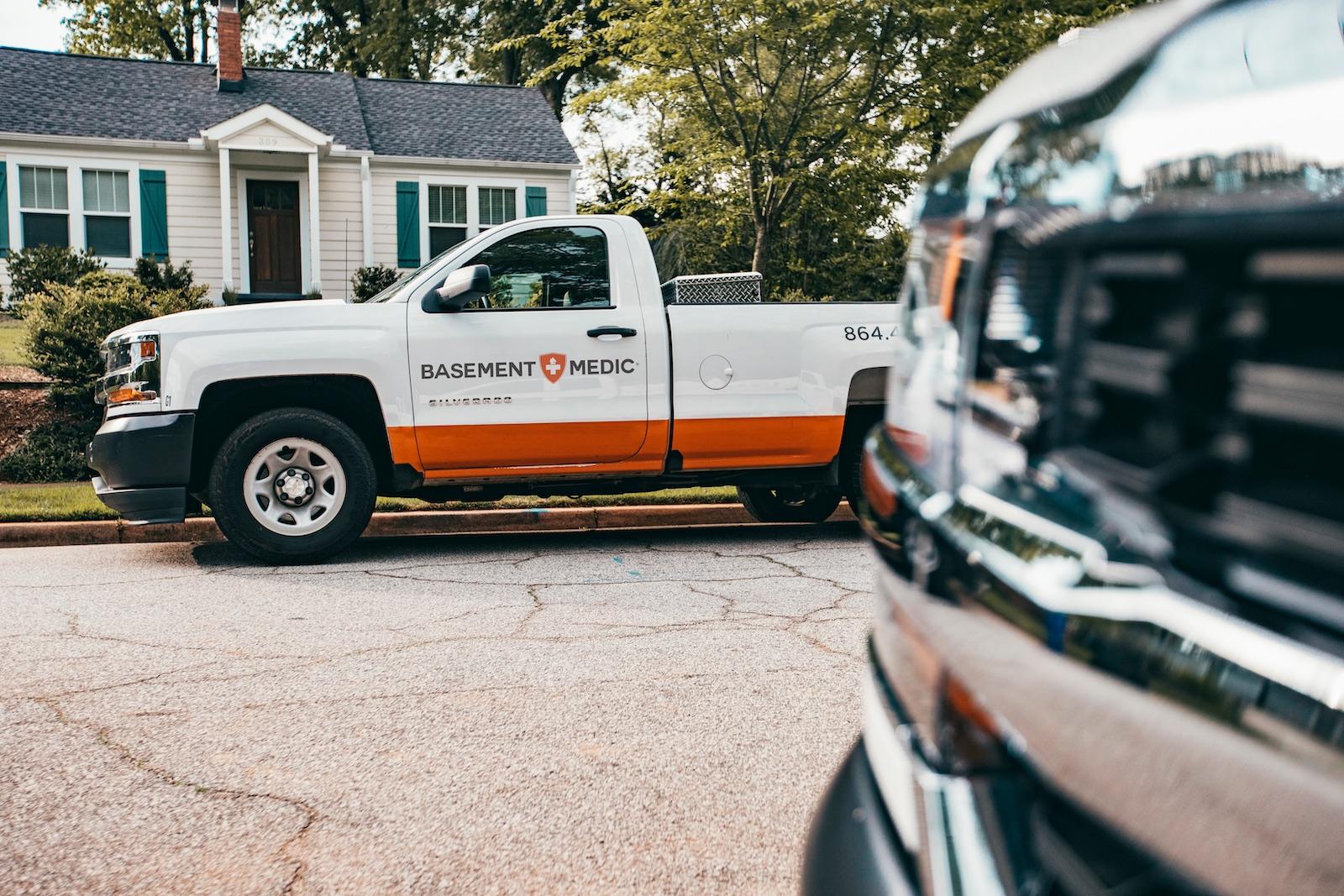 Basement Medic service truck parked in front of a customer's home before a basement waterproofing job