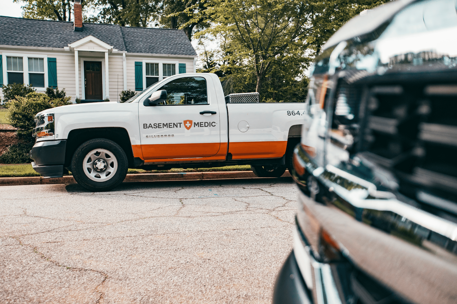 Basement Medic service truck parked in front of a customer's home before a basement waterproofing job